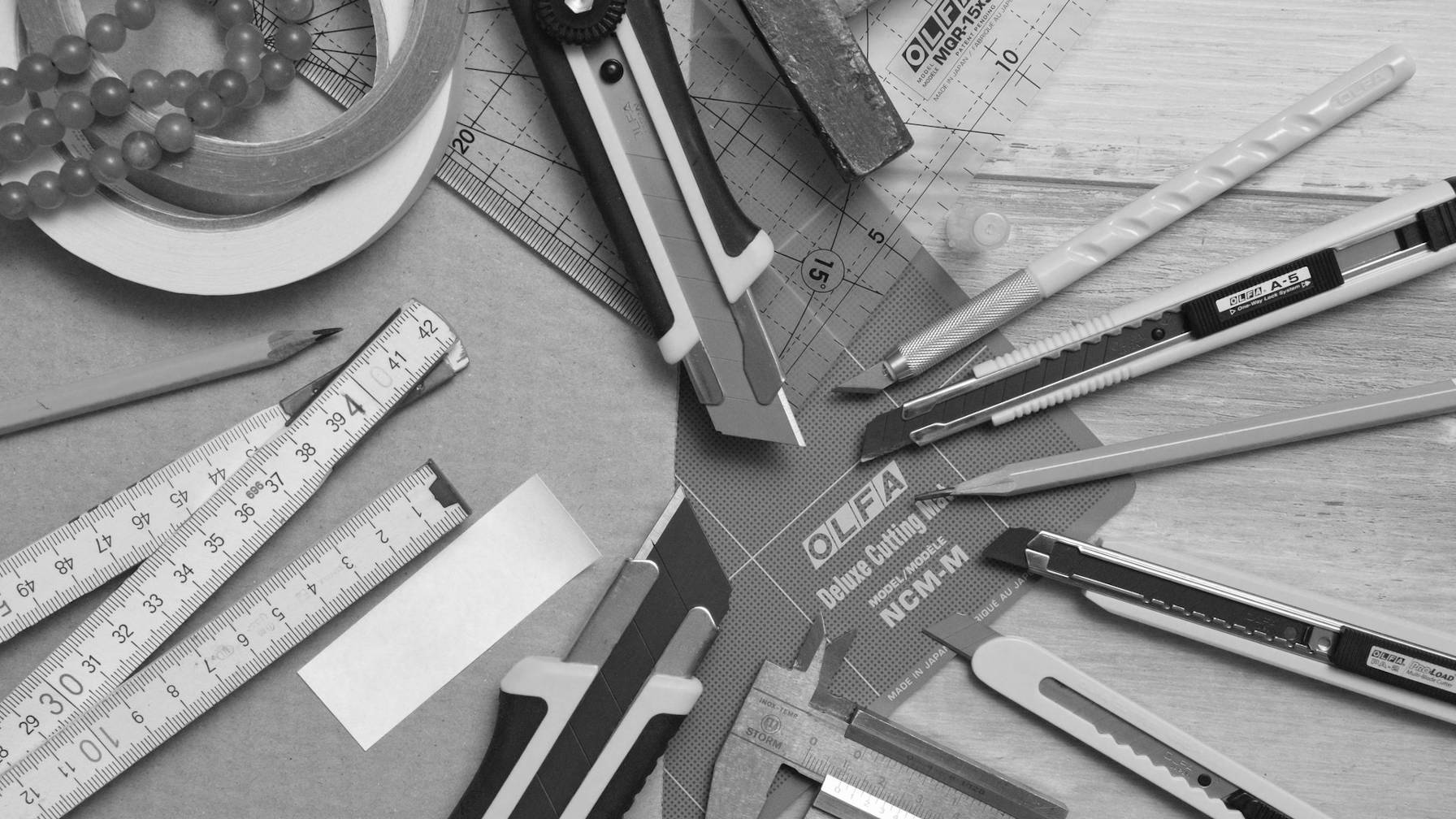 Règles, mesureurs de ruban, coupe-boîtes et crayons sur un bureau.